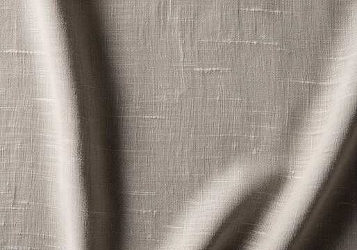 A detailed macro shot of a draped, textured fabric in a neutral beige tone, highlighting the weave and soft folds.
