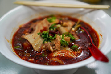 Side View of Mala Pork Soup with Peanuts and Herbs