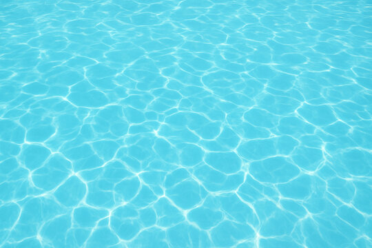 Refreshing summer swimming pool water background with sunlight reflections