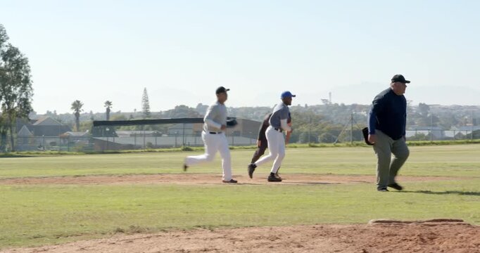 Male pitcher pitching prompting infielder tagging runner out, players celebrating on baseball field