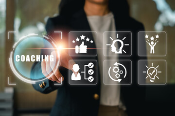 Businesswoman using virtual interface to illustrate coaching concepts, highlighting personal growth and professional development.