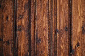 Naklejka premium Closeup view of a dark brown weathered wood plank texture with visible grain and knots