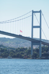 Bridge spans water with turkish flags waving in the breeze in istanbul 