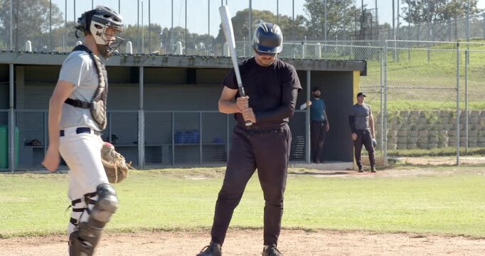 Receiving tosses from pitcher, male batter swinging bat, running toward first base in field drill