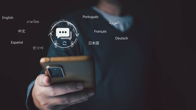 A man holds a phone with an AI translator app. A holographic icon shows multiple languages for global communication and learning. Technology and multilingual conversation concept.