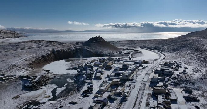 Aerial footage of  beautiful frozen lake and village in Tibet, China
