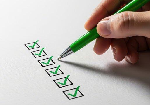 Hand marking a checklist with a green pen