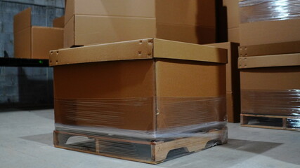 Almac&eacute;n con cart&oacute;n y tarimas de madera apiladas
Bodega industrial con material de empaque almacenado