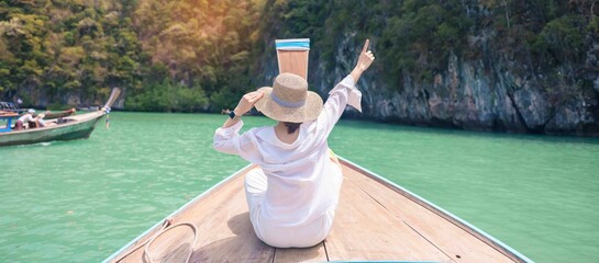 Happy Woman tourist in private longtail boat trip to koh Hong lagoon island at Krabi, Thailand....
