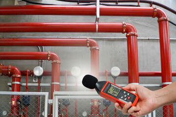 man is using a measuring sound level of a fire extinguishing system.Noise pollution prevention concept