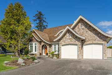 Two story stucco luxury house with nice spring blossom landscape in Vancouver, Canada, North America. Day time on May 2025.
