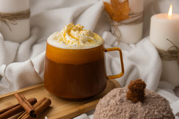 Pumpkin spiced latte morning warming coffee. Fall Drinks for Halloween Thanksgiving Holiday beverage Autumn spicy cinnamon flavor seasonal hot drinking in cozy orange cup. Atmosphere of cold rainy