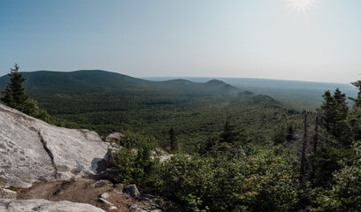 Panoramic View of Verdant Hills and Mountains from a Rocky Outcrop