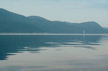 Sailboat Navigating Distant Waters with Mountains in Background