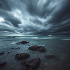 Obraz premium A dramatic seascape featuring dark storm clouds over a rocky shore with blurred water and a distant horizon
