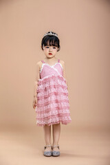 An Asian little girl in a pink dress