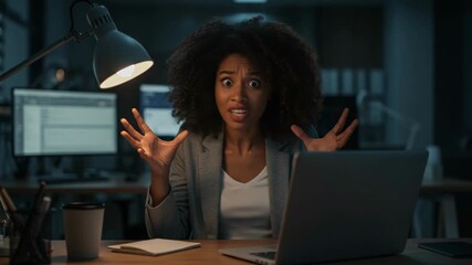 Young woman looking stressed and frustrated at her laptop screen in a dimly lit office late at night, overwhelmed by work - Powered by Adobe