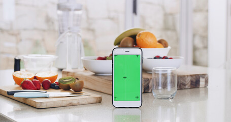 Green screen, smoothie and phone on kitchen counter for healthy diet, nutrition and fruit in house. Recipe, blender and technology with vegan ingredients for blog, shake or ui for tips in home