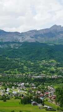 Vertical drone shot tilting the Servoz town, cloudy, summer day in Alps, France