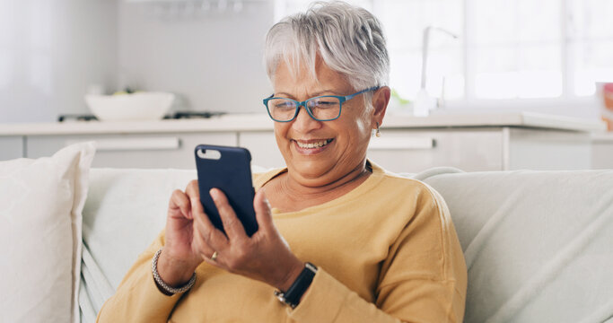 Senior woman, phone and smile on sofa for typing message, reading ebook or search online news. Retirement, old person and relax with smartphone in home for social media update or playing puzzle game - Powered by Adobe