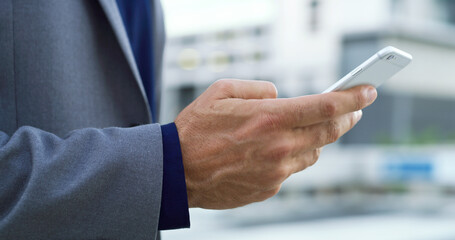 Phone, hands and businessman in city with communication, networking or email for finance report. Technology, professional and financial manager with cellphone for texting on mobile app in urban town.