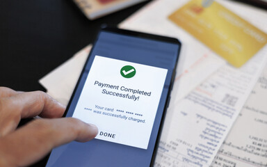 Fototapeta premium close up shot, man hand using mobile phone successfully paying credit card debt via mobile payment app