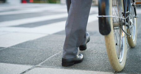 Bike, shoes and business man in city for carbon footprint, bicycle or eco friendly commute, Sustainability travel, cycling and legs of person walking outdoor for professional CSR transport and career