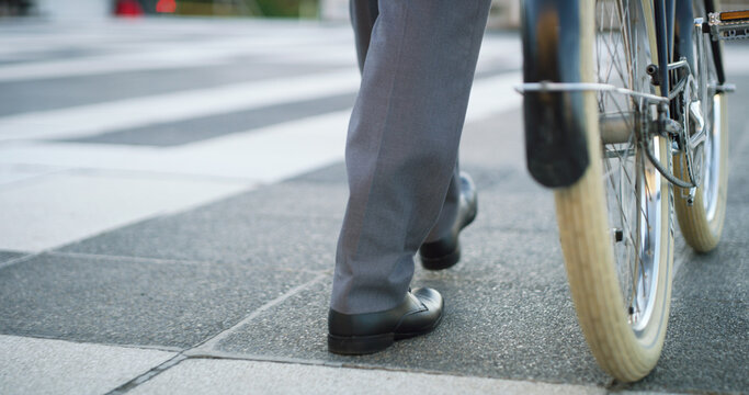Bike, shoes and business man in city for carbon footprint, bicycle or eco friendly commute, Sustainability travel, cycling and legs of person walking outdoor for professional CSR transport and career - Powered by Adobe