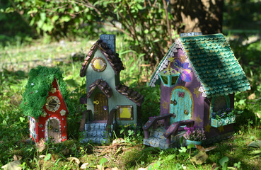 Cute fairy doll houses as village on the grass outside in the garden. Lovely miniature for greeting cards, wedding or birthday concept, real estate, downsizing, home ownership. Vintage background