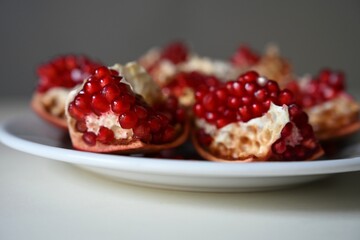 Juicy pomegranate pieces on a white plate – rich in vitamins, antioxidants, and fiber. Ideal for healthy diets, fitness nutrition, wellness blogs, and clean eating concepts