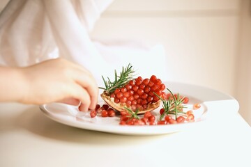 Fresh pomegranate seeds with rosemary on a white plate. A nutrient-rich superfood packed with antioxidants, ideal for nutrition blogs, dietitians, and healthy lifestyle content.