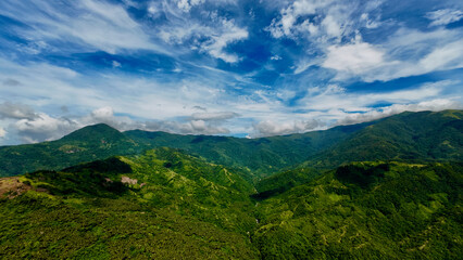 Tropical mountain landscape. View of mountain range in tropical region and white clouds.