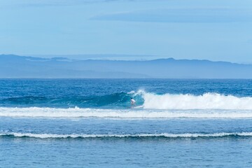 Surfer Catching a Wave on a Bright, Sunny Day