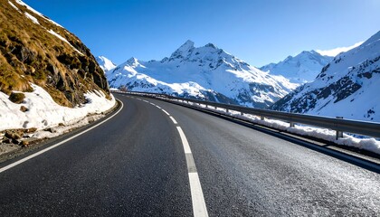 Winding mountain road through a snow-capped alpine landscape on a sunny day