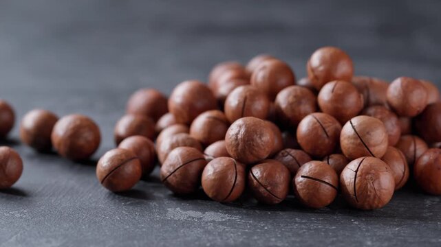 Pile of macadamia on a black stone table. Heap of macadamia on a black kitchen table.