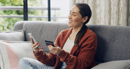 Credit card, online shopping and phone with happy woman on sofa in living room of home for...