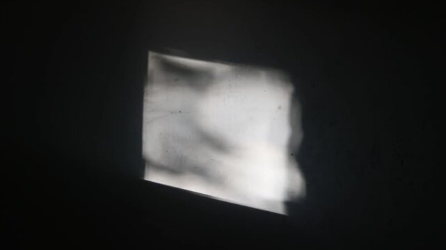 Light on the wall. Shadow around a white square. White wall in the light from the window.