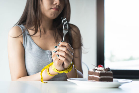 diet for good health concept. Woman tied her hand and restraint do not to eat sweet food.