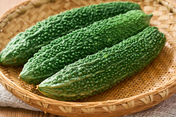 ゴーヤ｜沖縄の夏野菜を竹ざるに盛った食材イメージ