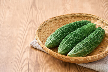 ゴーヤ｜沖縄の夏野菜を竹ざるに盛った食材イメージ