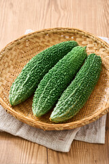ゴーヤ｜沖縄の夏野菜を竹ざるに盛った食材イメージ