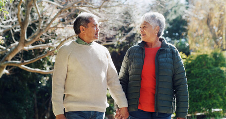Outdoor, holding hands and senior couple with love, conversation and bonding together with romance. Forest, happy man and woman with relationship, walking and peace with support, marriage and date