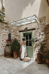 Rustic Elegance. Back View of Woman Walking Through Stone Courtyard, Soft and Nostalgic Tone