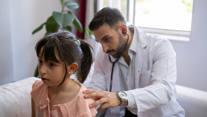 Young doctor examines girl in home environment.