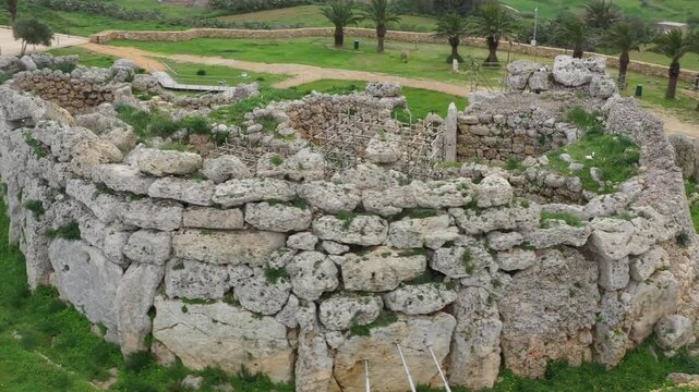 Drone shot of Ggantija Archaeological Park in Gozo with ancient stone temple ruins on green land