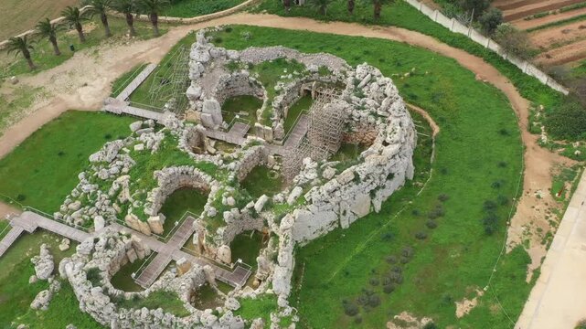 Drone shot of Ggantija Archaeological Park in Gozo with ancient stone temple ruins on green land