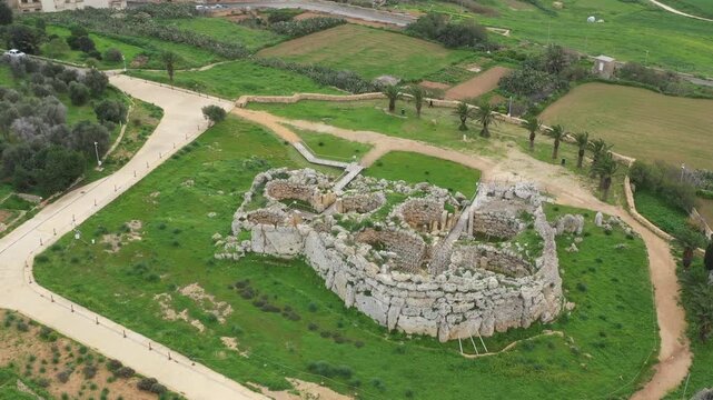 Drone shot of Ggantija Archaeological Park in Gozo with ancient stone temple ruins on green land