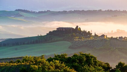 Misty morning landscape of rolling hills in Tuscany.