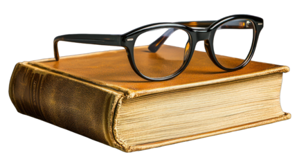 Glasses sit atop a worn, golden, aged hardcover book