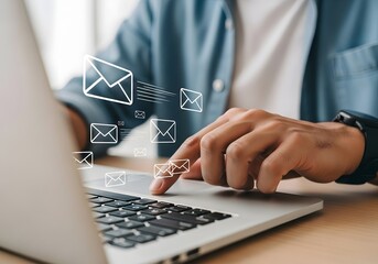 Person using laptop with email symbols floating above keyboard sending multiple messages quickly now